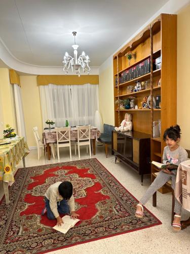 two children playing in a living room with a rug at Guest House Train Station Venice - Atika & Atif in Mestre