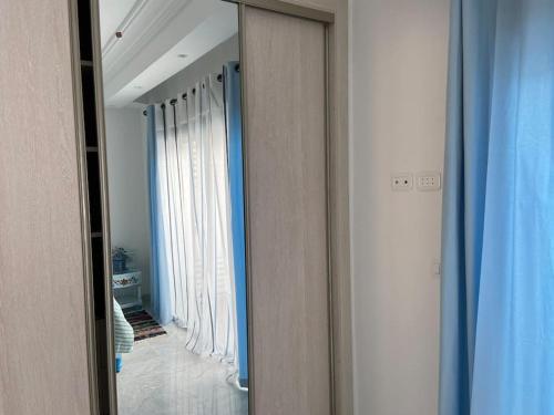 a mirror in a room with a hallway with curtains at Marsa Central Splendid Appart 2 in La Marsa