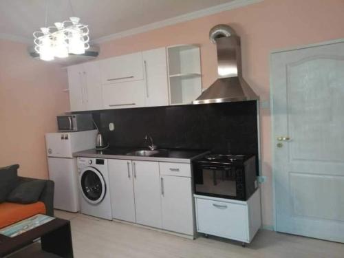 cocina con fogones, fregadero y microondas en Апартаменти Арт, en Stara Zagora