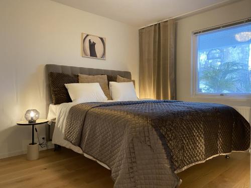 a bedroom with a large bed with a window at Luxurious villa with free parking in Gothenburg