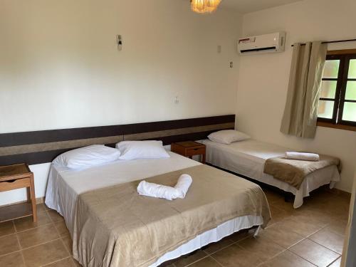 um quarto com 2 camas e toalhas em Canto de Itamambuca em Ubatuba