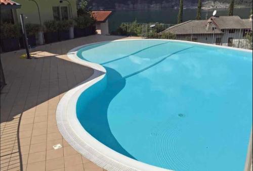 una grande piscina con acqua blu in un cortile di Sun Lake Iseo apartment a Sale Marasino