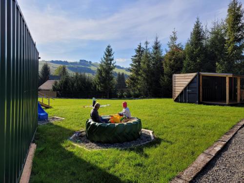 two people are sitting in an inflatablelatablelatable at Woodbox Istebna in Istebna