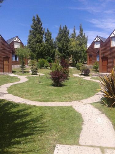 un camino sinuoso en un patio con casas en Cabañas Huenco en El Calafate