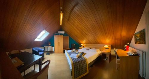 een slaapkamer met een bed en een tafel in een kamer bij Hotel Restaurant Hestia in Eijsden