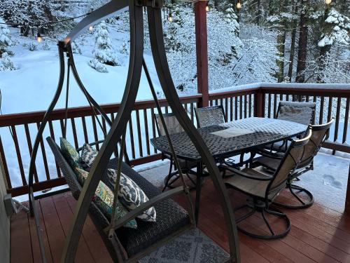 a table and chairs on a porch in the snow at YoBee! Park Reservation Included! Heart of Yosemite - Homey Studios and Breakfast in Yosemite West