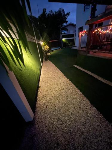 a garden with a gravel pathway at night at Scarlett Studios 2 - US Embassy Appt 7 mins drive-Lloyd Erskine Sandiford Centre Ross University 5 mins drive - Only the 1 night package includes Airport and Embassy roundtrip in Bridgetown