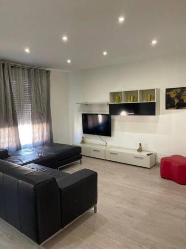 Lujoso y amplio apartamento en Crevillente في كريفايلنت: غرفة معيشة مع أريكة وتلفزيون بشاشة مسطحة