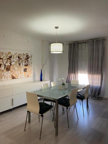 Lujoso y amplio apartamento en Crevillente في كريفايلنت: غرفة طعام مع طاولة وكراسي زجاجية