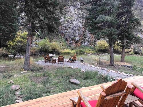 a group of chairs sitting on top of a deck at Newly Renovated Creekside Cabin! in Almont