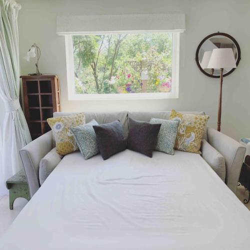 a large white bed in a room with a couch at Canal view 2 bedrooms end of terrace in Chichester