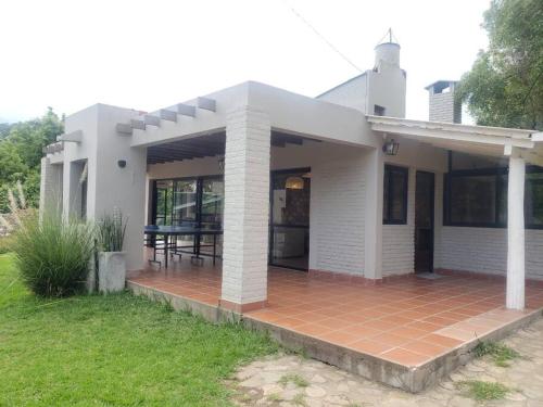 a small white house with a brick patio at Vaqueros Jauzz casa de campo in Vaqueros