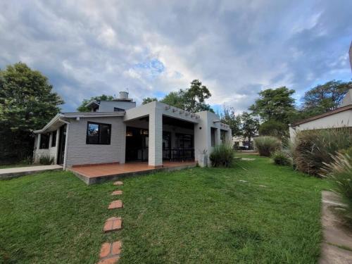 una casa blanca con césped delante en Vaqueros Jauzz casa de campo en Vaqueros