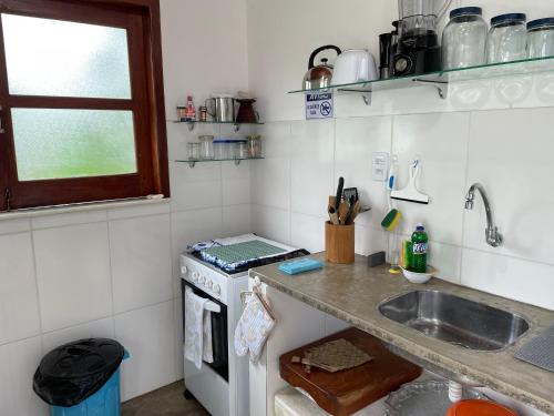 a small kitchen with a sink and a stove at Casa paradise perto da praia Guarajuba - BA in Camacari