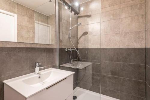 bagno con lavandino e doccia con specchio di joli appartement avec balcon proximité lac ad Annecy