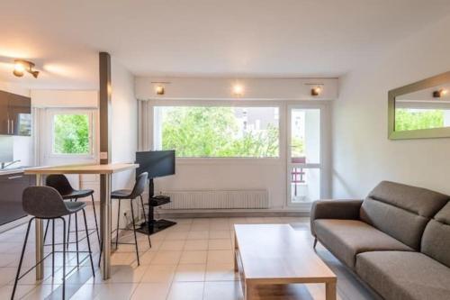un salon avec un canapé et une table dans l'établissement joli appartement avec balcon proximité lac, à Annecy