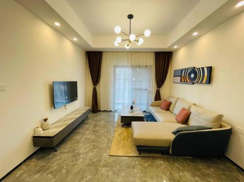 a living room with a couch and a tv at Embassy Access Golf Apartment in Kigali