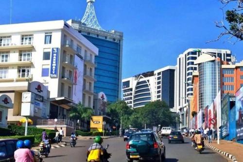 a group of motorcycles driving down a city street with buildings at Embassy Access Golf Apartment in Kigali