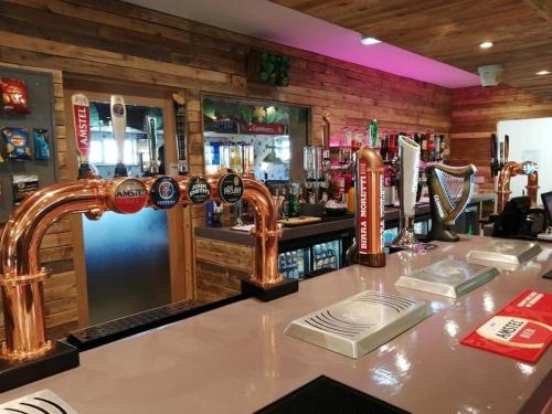a bar with copper faucets on a counter at Golden Sands Caravan Hire Ingoldmells- FREE in caravan wifi- Access included to the on site club house, sports bar, arcade, coffee shop We have beach access, a fishing lake and a laundrette in Ingoldmells