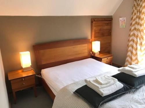 a bedroom with two beds and two lamps on tables at The Stone Cottage - Bruny Island in Simpsons Bay