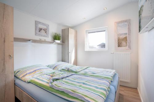 ein Schlafzimmer mit einem Bett und zwei Fenstern in der Unterkunft Casa del Sol Scharbeutz - Sauna kostenlos - 1 kleiner Hund willkommen &ndash eingezäunter Garten in Scharbeutz