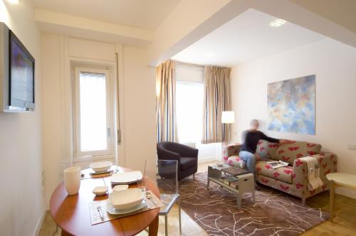 un homme assis sur un canapé dans un salon dans l'établissement Residenza Matteotti, à Syracuse