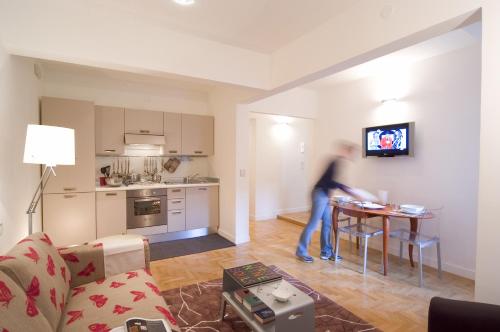 une personne dans un salon avec une cuisine dans l'établissement Residenza Matteotti, à Syracuse