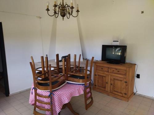 uma sala de jantar com mesa e cadeiras e uma televisão em Morgana em Cuchilla Alta