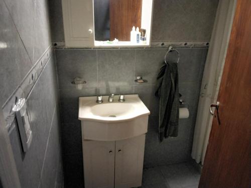 Baño pequeño con lavabo y espejo en Casa La Pausa en Miramar