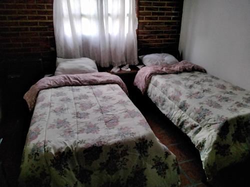 2 camas en una habitación con ventana en Casa La Pausa en Miramar