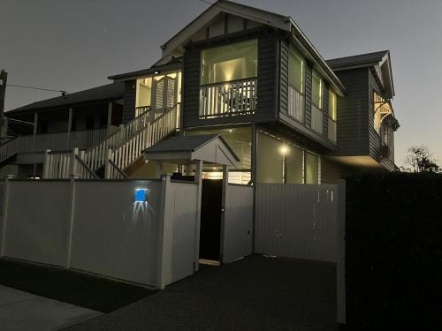 a house with a fence in front of a gate at Old Queensland Charm Entire upper level in Brisbane