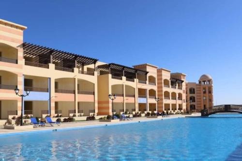 una grande piscina di fronte a un edificio di fully finished, very cozy and comfortable studio -Marina city Residence a Port Ghalib