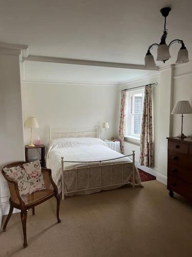 - une chambre avec un lit, une chaise et une fenêtre dans l'établissement Beautiful, rustic bungalow, à Reydon