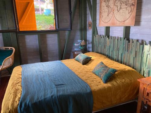 ein Schlafzimmer mit einem Bett in einer Holzhütte in der Unterkunft Papaye Lodge sur les flancs des Monts Caraïbes in Vieux-Fort