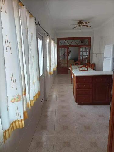 an empty room with a kitchen and a room with windows at Azores House in Ponta Delgada