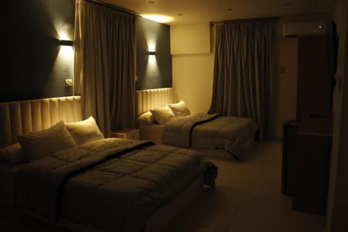 a hotel room with two beds in a dark room at METROPOLITANO in Cairo