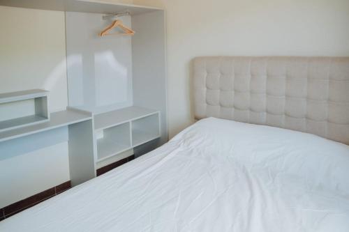 a bedroom with a white bed and a white headboard at LAS LOICAS in Esquel