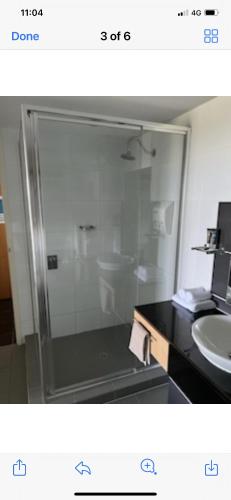 a bathroom with a glass shower and a sink at Pelican Waters Resort One Bedroom Apartment in Pelican Waters