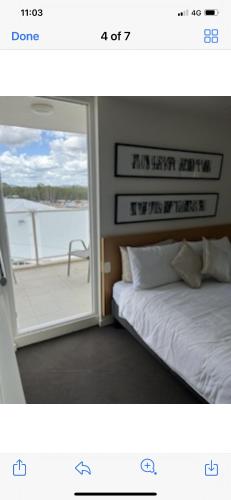 a room with a bed and a window with a view at Pelican Waters Resort One Bedroom Apartment in Pelican Waters