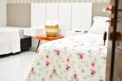 a bedroom with a bed with pink flowers on it at Lukinhas Pousada in Nobres