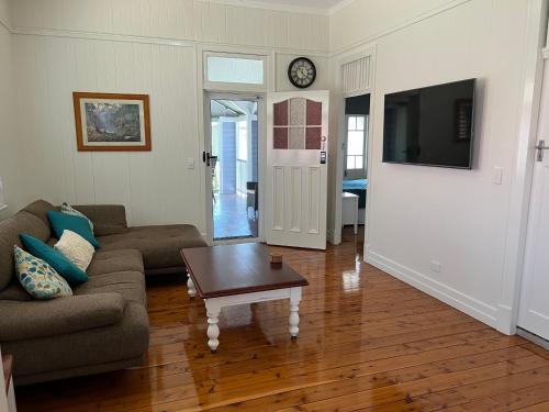 a living room with a couch and a coffee table at Old Queensland Charm Entire upper level in Brisbane