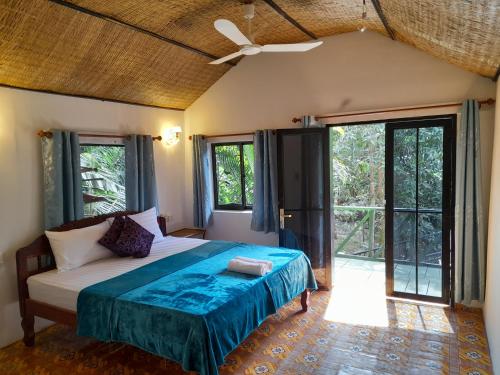 a bedroom with a bed and large windows at Green Mango Bungalows in Kampot