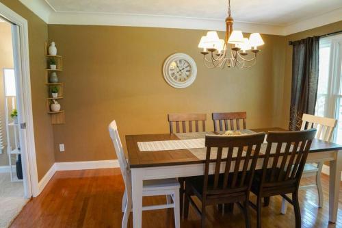 a dining room table with chairs and a clock on the wall at 4BR/2.5BA Home boasting 2400sqft and Eat-in KTN in Toledo