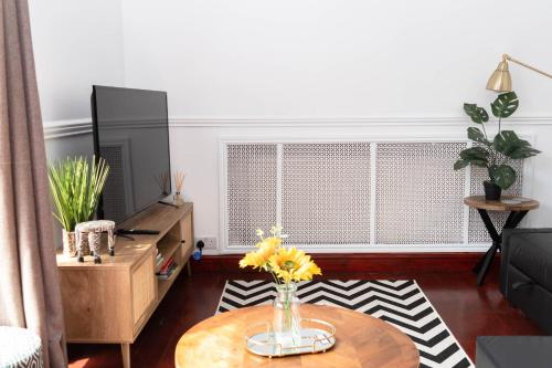 a living room with a coffee table and a window at Hale Lodge in London