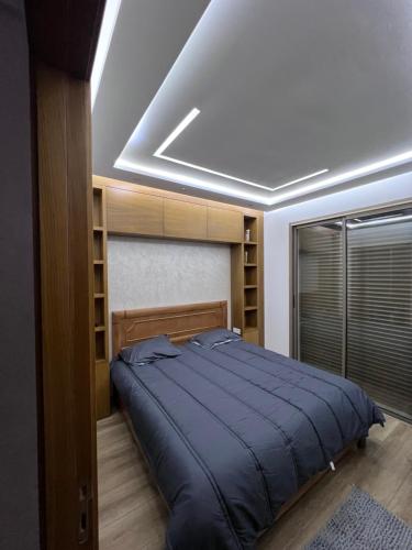 1 dormitorio con 1 cama con edredón azul en Résidence majorel en Kenitra