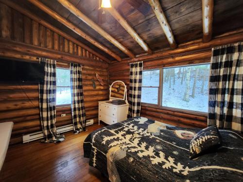 a bedroom with a bed in a log cabin at Adirondack Diamond Point Lodge in Lake George