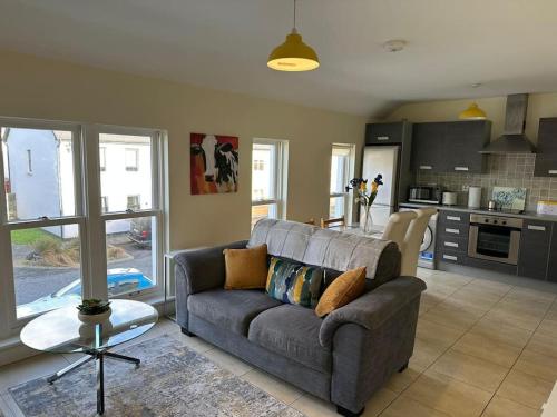 a living room with a couch and a kitchen at Town Centre Apartment in Westport