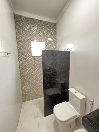 a white bathroom with a toilet and a shower at Casa Olímpia - SP in Olímpia