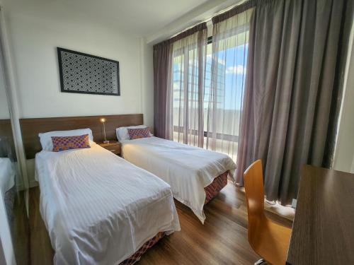 a hotel room with two beds and a window at Exodus Dandenong Apartment Hotel in Dandenong