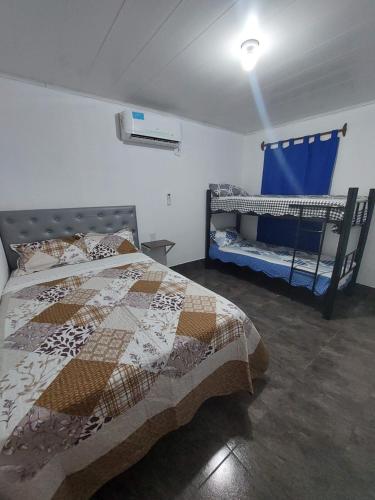 1 dormitorio con 1 cama y 2 cunas en Cabañas Termas de Reyes en Termas de Río Hondo